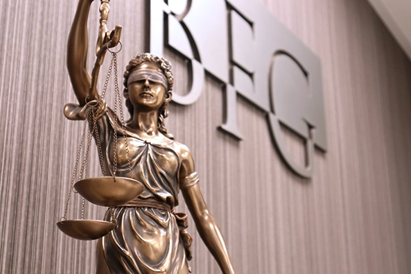 Statue of Lady Justice in front of the Bangerter Frazier Group Logo