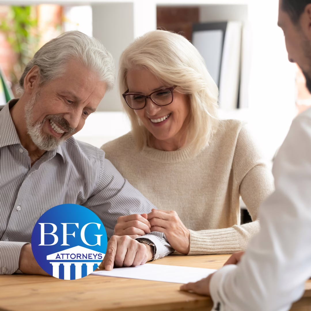 an older couple signing their estate planning documents with their attorney